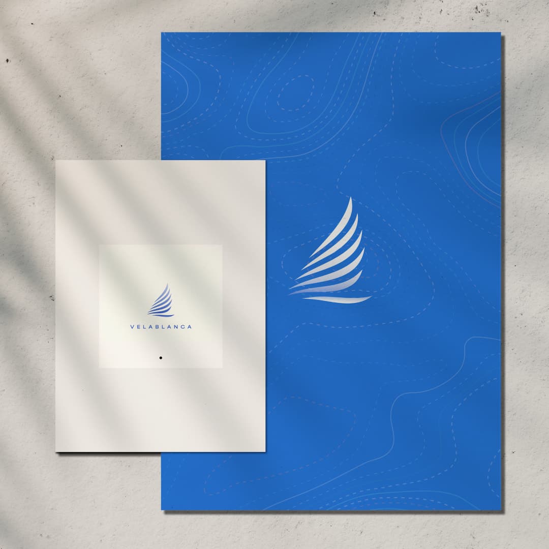 Carpeta azul con patrón topográfico y tarjeta con el logotipo de Velablanca